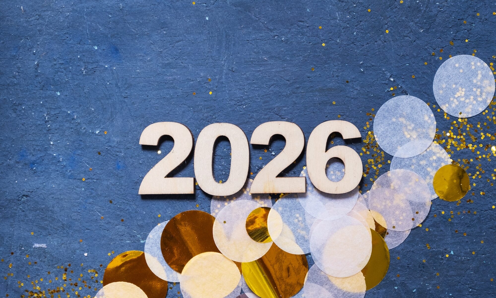 New year 2026 congrats from JoopeA Foundation with shiny confetti pieces scattered on a dark blue surface.