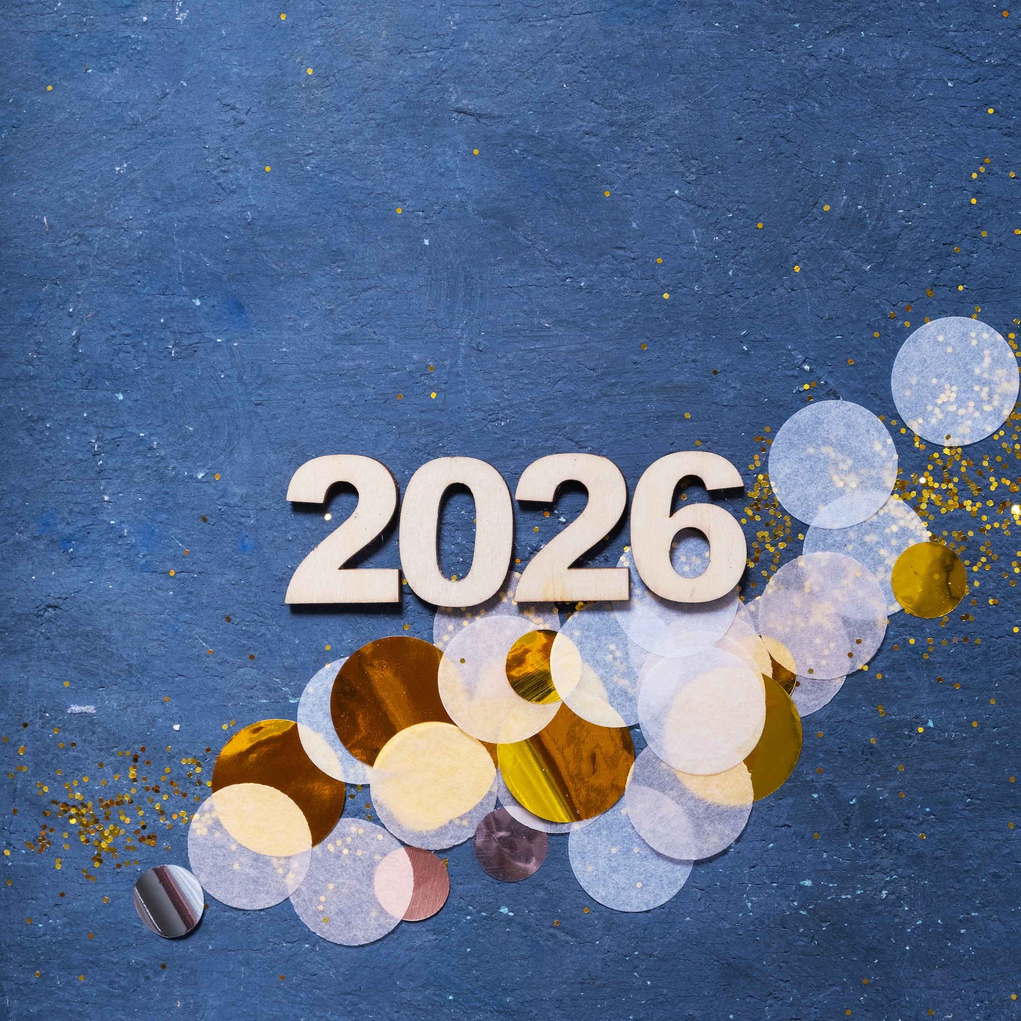 New year 2026 congrats from JoopeA Foundation with shiny confetti pieces scattered on a dark blue surface.